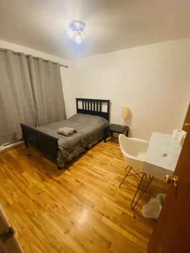 ein Schlafzimmer mit einem Bett, einem Tisch und einem Stuhl in der Unterkunft Ideal for group 3 bedroom apartment in Montreal