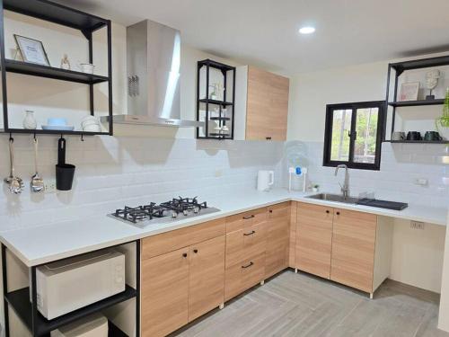 a kitchen with a stove and a sink at Kiddie Hostel Unit 30B-kids and pets friendly in Subic bay freeport zone in Kababae