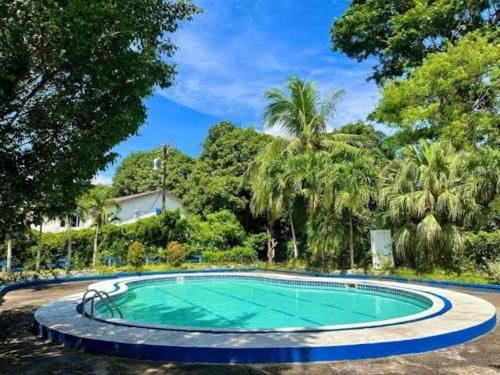 una piscina en un patio con árboles en Kiddie Hostel Unit 30B-kids and pets friendly in Subic bay freeport zone en Kababae