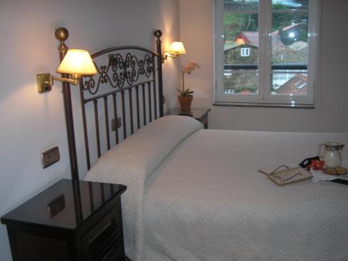 a bedroom with a bed with a lamp and a window at Pension Residencia Ria De Muros in Muros
