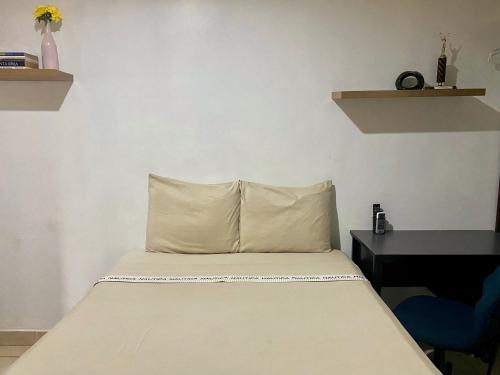 a bed with a pillow and a desk in a room at Suite Noa Apartamento in San Pedro Sula