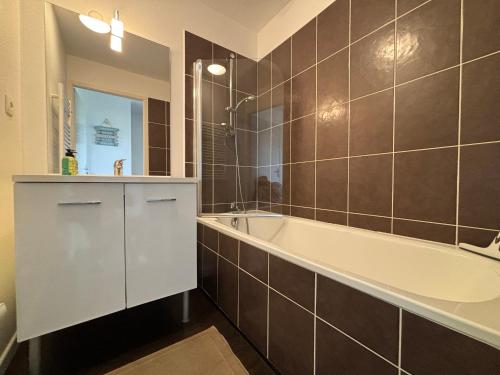 a bathroom with a tub and a sink and a mirror at Maison 2 chambres au calme avec piscine, proche plages et commerces - FR-1-197-484 in Talmont-Saint-Hilaire