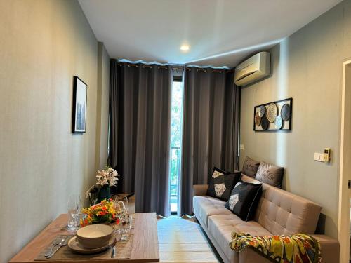 una sala de estar con un sofá y una mesa en zcape 2 boat avenue by sahana, en Ban Thalat Choeng Thale
