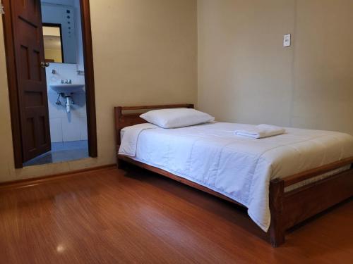 1 dormitorio con cama, lavabo y espejo en Casa Colon Quito Bed & Breakfast Hostel, en Quito