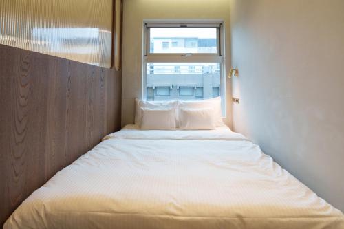 a large bed in a room with a window at PAPO'A Harbor Hotel in Kaohsiung