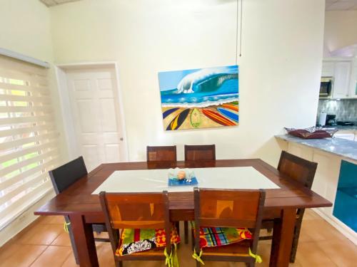 a dining room table with chairs and a painting on the wall at Oasis de Tranquilidad in Colón