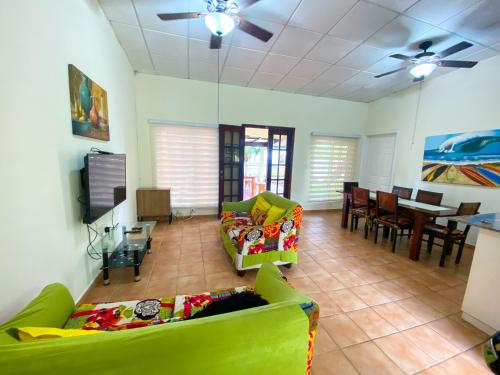 a living room with green couches and a dining room at Oasis de Tranquilidad in Colón