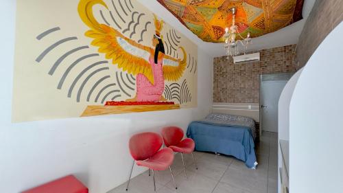 a room with a mural on the wall and red chairs at Hotel das Palmas in Florianópolis