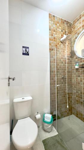 a bathroom with a toilet and a glass shower at Hotel das Palmas in Florianópolis