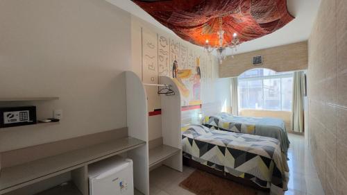 a bedroom with two twin beds and a chandelier at Hotel das Palmas in Florianópolis