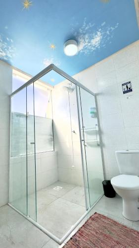 a bathroom with a glass shower and a toilet at Hotel das Palmas in Florianópolis