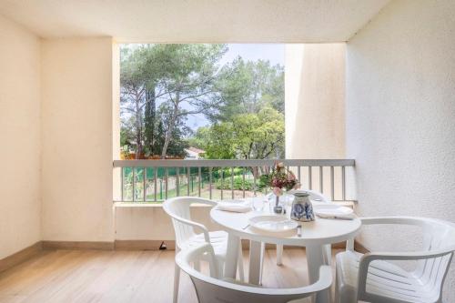 une table blanche et des chaises dans une pièce avec une fenêtre dans l'établissement Appartement Samoa - Welkeys, à Saint-Mandrier-sur-Mer
