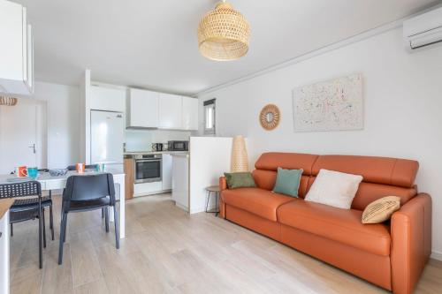 un salon avec un canapé orange et une cuisine dans l'établissement Appartement Samoa - Welkeys, à Saint-Mandrier-sur-Mer