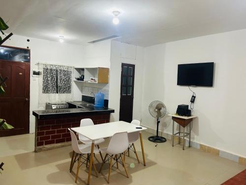 Departamento de 3 habitaciones في بوكالبا: مطبخ مع طاولة وكراسي في غرفة