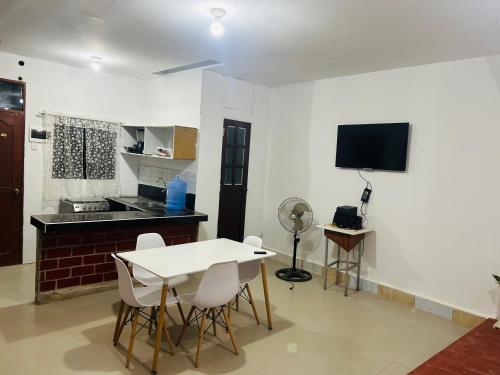 Departamento de 3 habitaciones في بوكالبا: غرفة معيشة مع طاولة وكراسي وتلفزيون