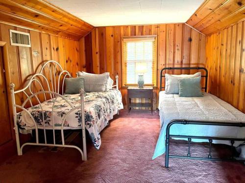 Paragould的住宿－Willow Oaks Cottage，一间卧室设有两张床、一张桌子和一个窗口