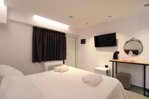 a bedroom with a white bed with towels on it at Melina's Seaside Retreat in Ksamil