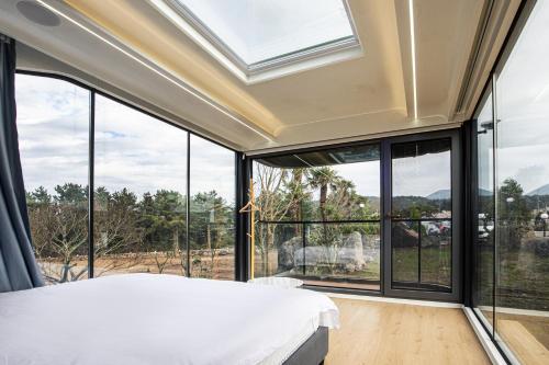 um quarto com uma cama e janelas grandes em New Korea Resort em Kŭmdŏng-ni