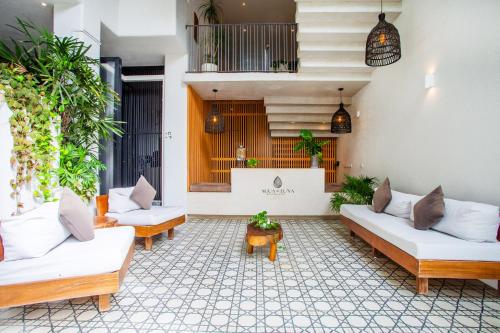 a living room with white couches and plants at Agua de Luna Boutique Hotel in San Francisco