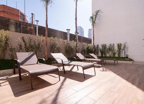 a group of chairs sitting on a patio at Studio Lupi in Sao Paulo