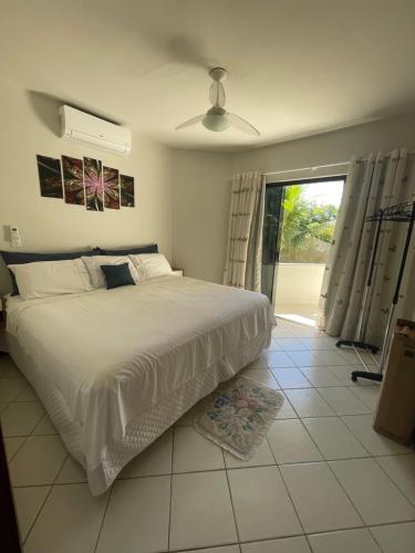 a bedroom with a large bed and a sliding glass door at Colione House in Balneário Camboriú