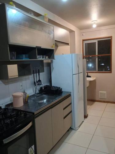 cocina con nevera blanca y fregadero en Apartamento no bairro João Pessoa, en Jaraguá do Sul