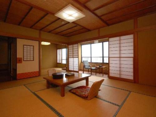 a living room with a table and a dining room at AtamiOnsen Nagahamaen in Atami