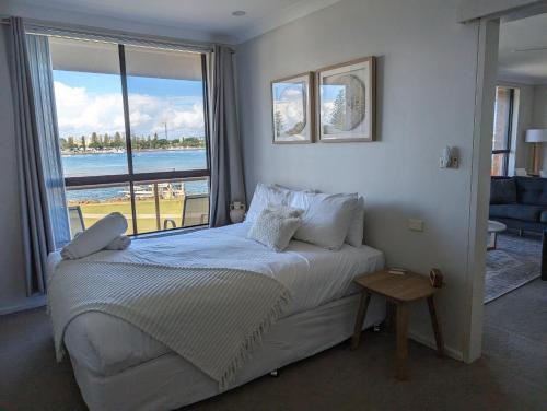 a bedroom with a bed with a view of the ocean at Shoreline Unit 8 in Tuncurry