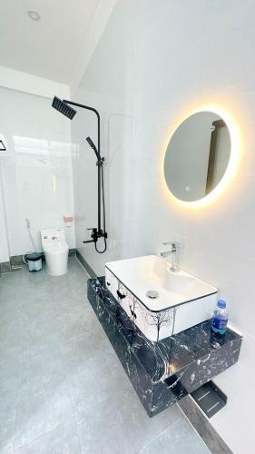 a white bathroom with a sink and a mirror at Pink Sea Villa in Cu Lao Thu
