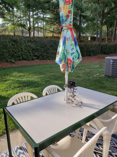 a table with chairs and an umbrella on top of it at Gathering Place in Charlotte