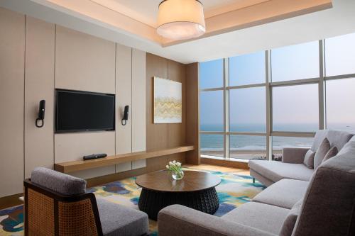 a living room with a couch and a tv at Crowne Plaza Beihai Silver Beach by IHG in Beihai