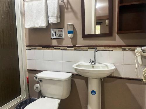 a small bathroom with a toilet and a sink at Merendon Suite Apartamento in San Pedro Sula