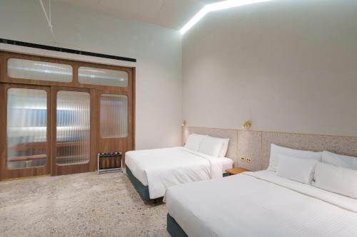 a hotel room with two beds and a window at PAPO'A Harbor Hotel in Kaohsiung
