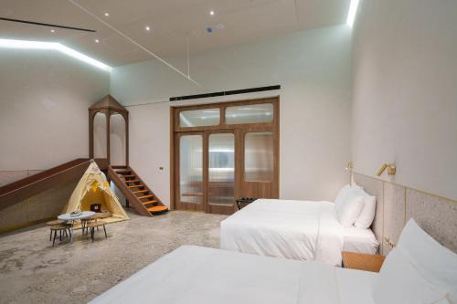 a bedroom with a bed and a staircase and a room with a tent at Papoa Harbor Hotel in Kaohsiung