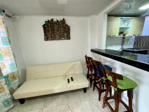 a living room with a white couch and chairs at Los Almendros Beach in San Andrés