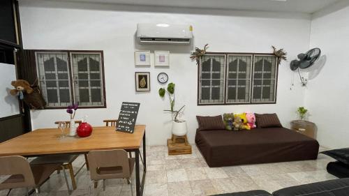 a living room with a couch and a table at บ้านเพื่อน @อุทัยธานี in Ban Don Khwang
