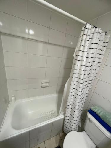 a bathroom with a white tub and a toilet at Departamento de 3 dormitorio in Santiago