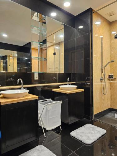 a bathroom with two sinks and a shower at Cosy Apartment at KL City Centre in Kuala Lumpur
