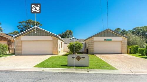 a house with two garages and a street sign in front at River Luxury in Iluka