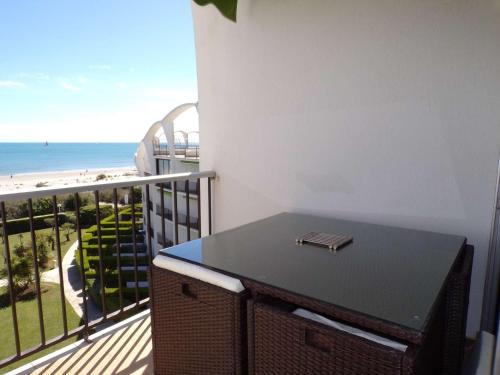 d'un balcon avec une table et une vue sur la plage. dans l'établissement Appartement 2 pièces avec piscine, garage, et WIFI à La Grande-Motte - FR-1-328-220, à La Grande Motte