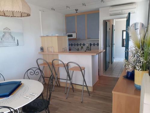 une cuisine et une salle à manger avec une table et des chaises dans l'établissement 3 pièces avec grande terrasse à 50m de la plage et commerces, parking privé - FR-1-328-225, à La Grande Motte