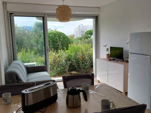 Il comprend un salon avec une cuisine équipée d'une table et d'un réfrigérateur. dans l'établissement Studio Cabine Rénové Proche Plage, Commerces, Clim, WIFI, Parking - FR-1-328-230, à La Grande Motte