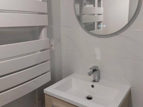 une salle de bain blanche avec un lavabo et un miroir dans l'établissement Studio Cabine Rénové Proche Plage, Commerces, Clim, WIFI, Parking - FR-1-328-230, à La Grande Motte