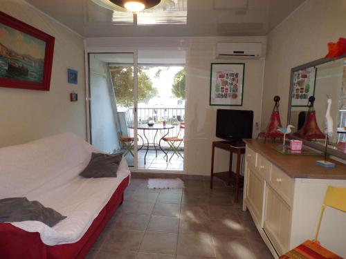 une chambre avec un lit et une télévision et un balcon dans l'établissement Studio Calme et Moderne avec Parking Privé, à 500m de la Plage - La Grande-Motte - FR-1-328-241, à La Grande Motte