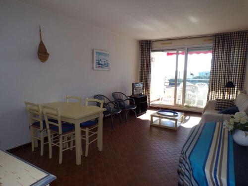 un salon avec un lit, une table et des chaises dans l'établissement 3 pièces avec piscine, proche plage, wifi, parking - idéal familles - FR-1-328-257, à La Grande Motte