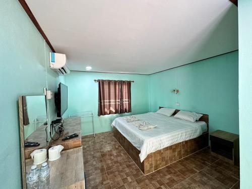 sypialnia z łóżkiem i telewizorem w obiekcie สวนสบายปลายนารีสอร์ท w mieście Ban Hin Lat