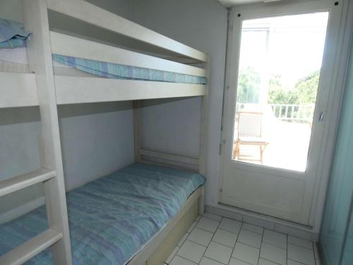 - une petite chambre avec des lits superposés et une fenêtre dans l'établissement Studio cabine avec piscine, climatisation, garage, à 300m plage - FR-1-328-259, à La Grande Motte