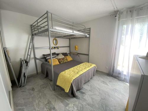 - une chambre avec des lits superposés en métal et des draps jaunes dans l'établissement Villa La Grande-Motte, 3 pièces, 6 personnes - FR-1-328-222, à La Grande Motte