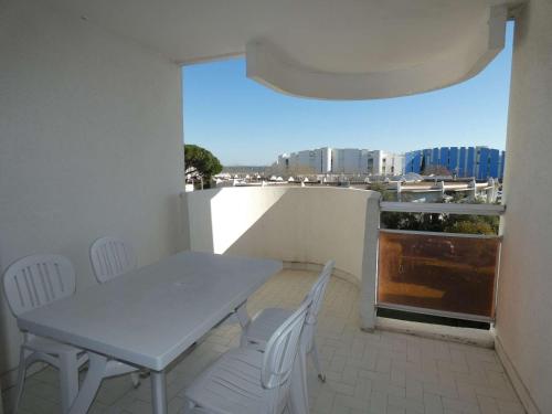 une table et des chaises sur un balcon avec vue dans l'établissement Appartement T2 Cabine à La Grande-Motte, Proche Plage et Commerces, Parking Privé - FR-1-328-224, à La Grande Motte
