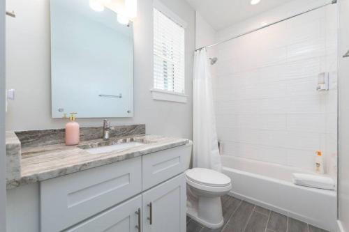 傑克遜維爾海灘的住宿－Be a Nomad - Newly renovated 4 blocks to beach，白色的浴室设有水槽和卫生间。